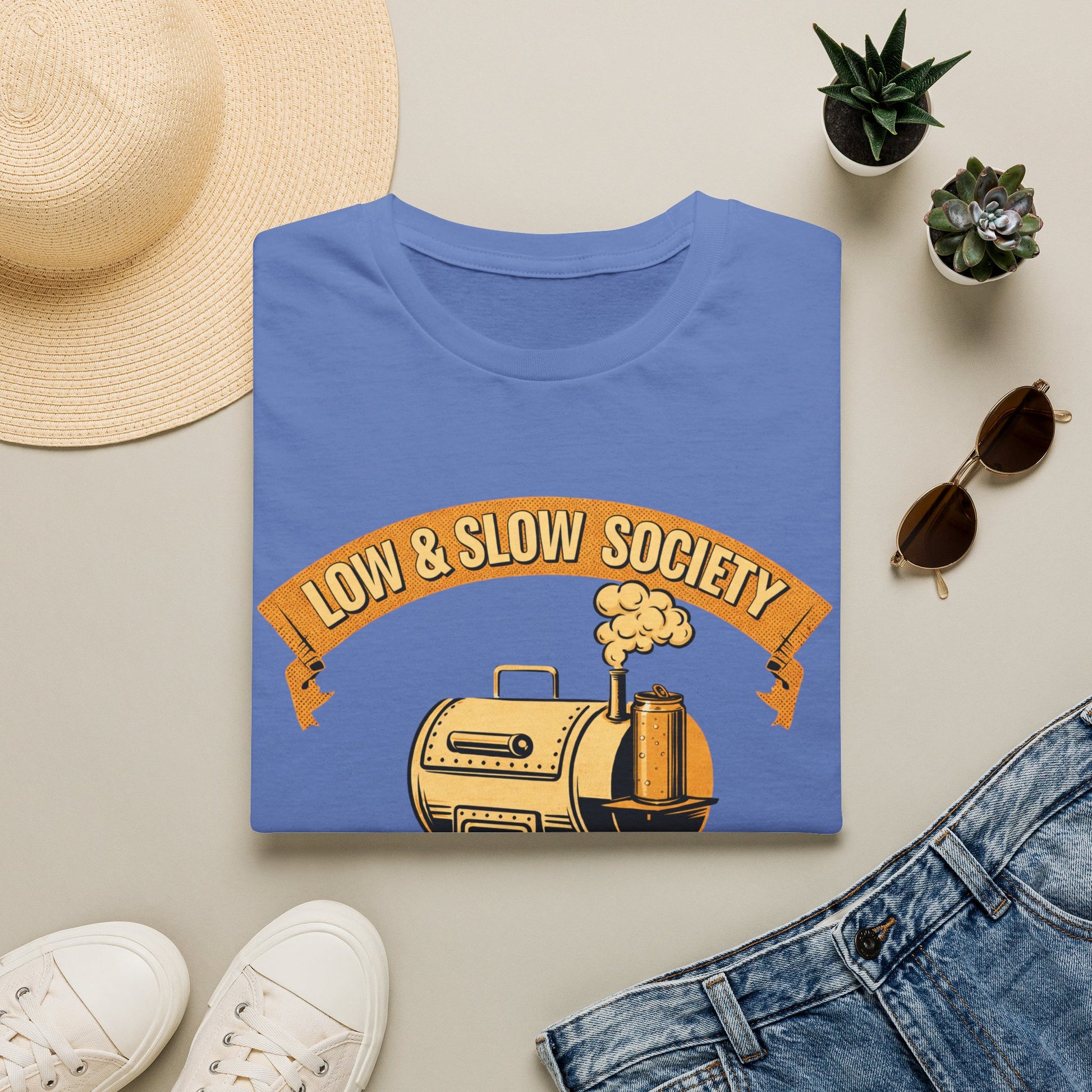 Low & Slow Society Shirt, Iris periwinkle, folded flat lay styled with a straw hat, sunglasses, sneakers and denim