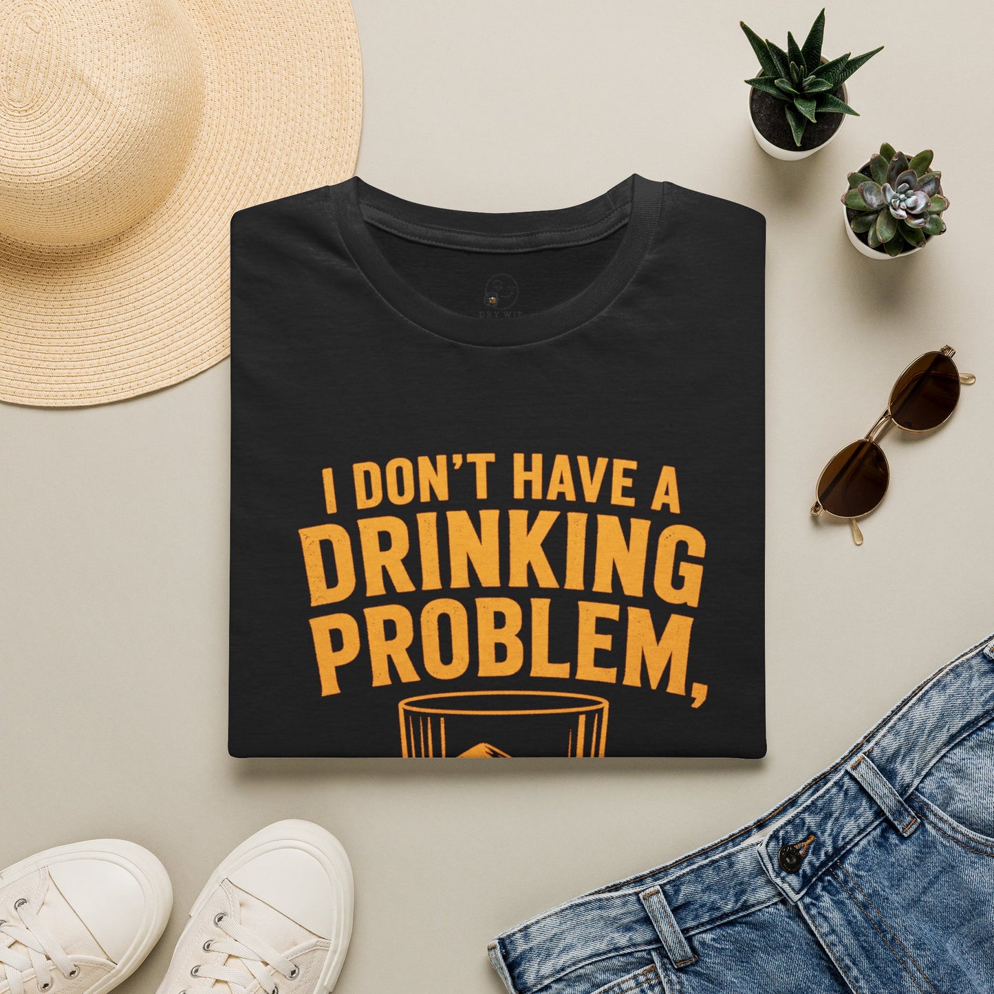 I Don't Have a Drinking Problem Shirt, Black, folded flat lay styled with a straw hat, sunglasses, sneakers and denim