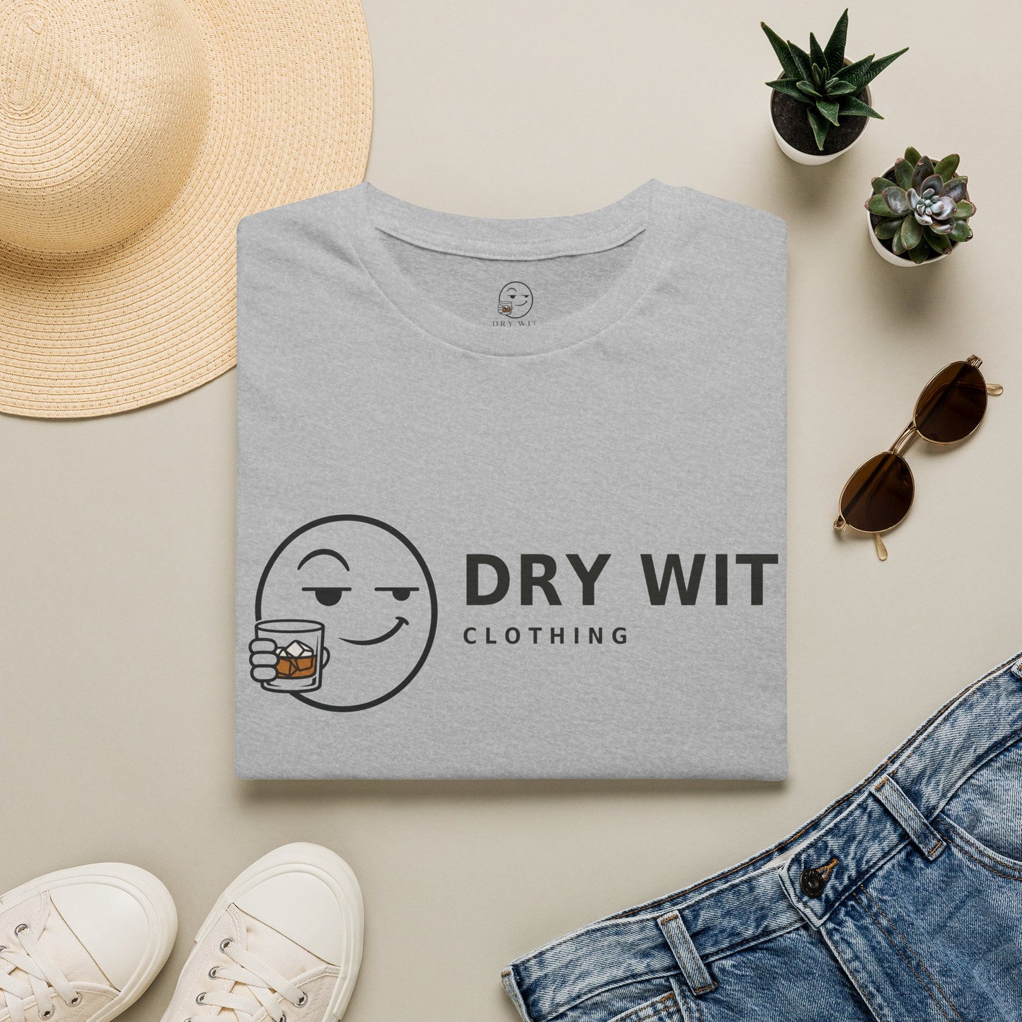 Dry Wit Logo Shirt, Sport Grey, folded flat lay styled with a straw hat, sunglasses, sneakers and denim