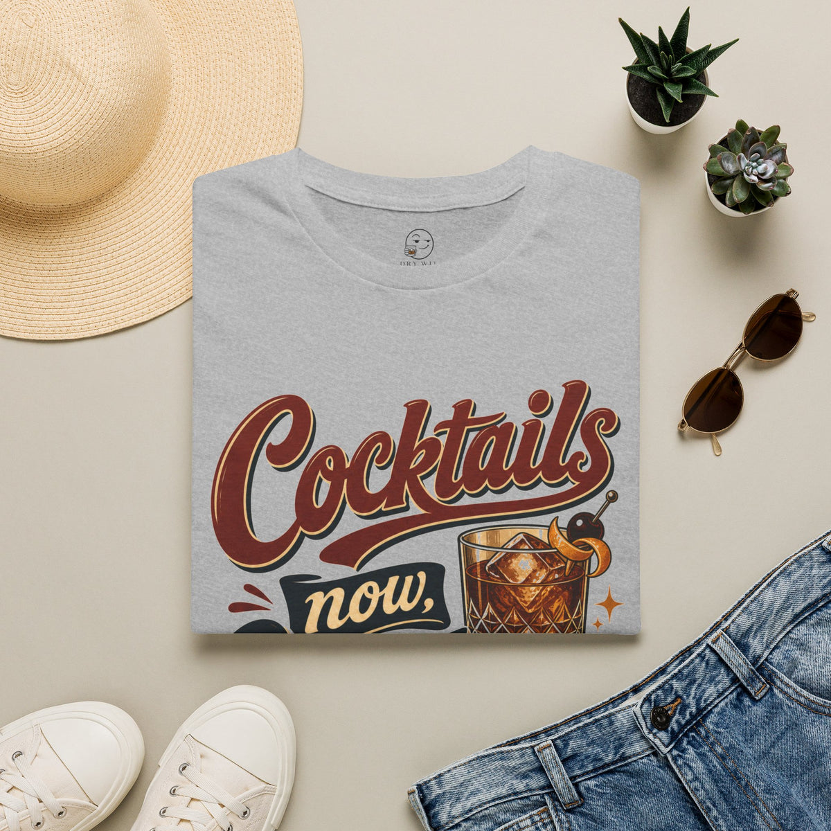 Cocktails Now, Questions Later Shirt, Sport Grey, folded flat lay styled with a straw hat, sunglasses, sneakers and denim
