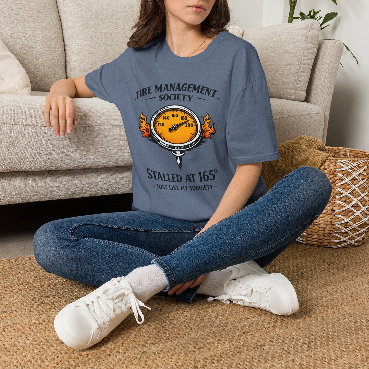 Fire Management Society Shirt, Heather Indigo slate blue, worn by a model seated on the floor beside a sofa