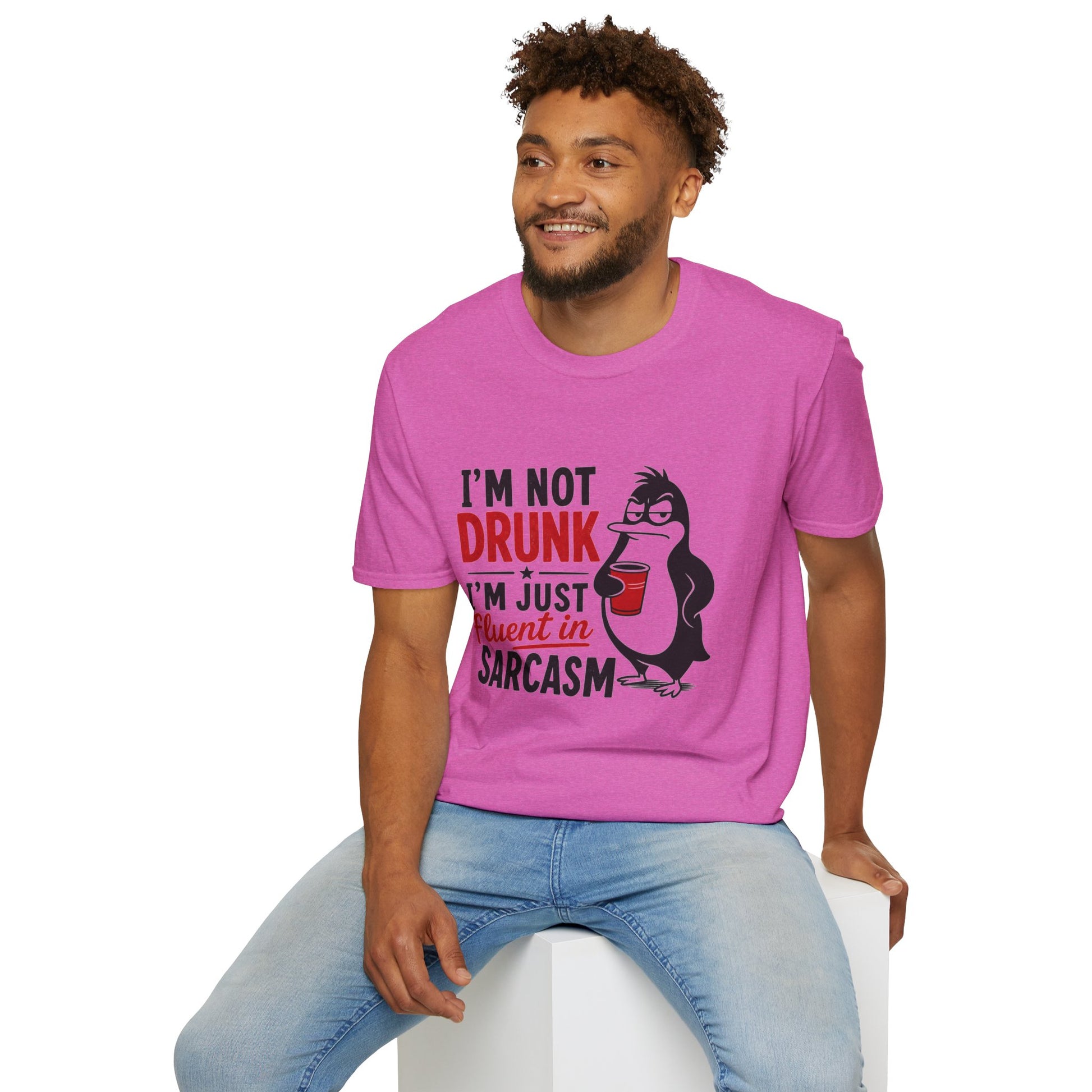 I'm Not Drunk, I'm Just Fluent in Sarcasm Shirt, Heather Berry pink, worn by a model seated on a white block