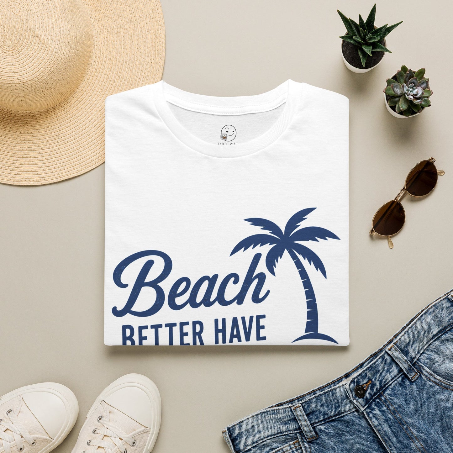 Beach Better Have My Cocktail Shirt, White, folded flat lay styled with a straw hat, sunglasses, sneakers and denim