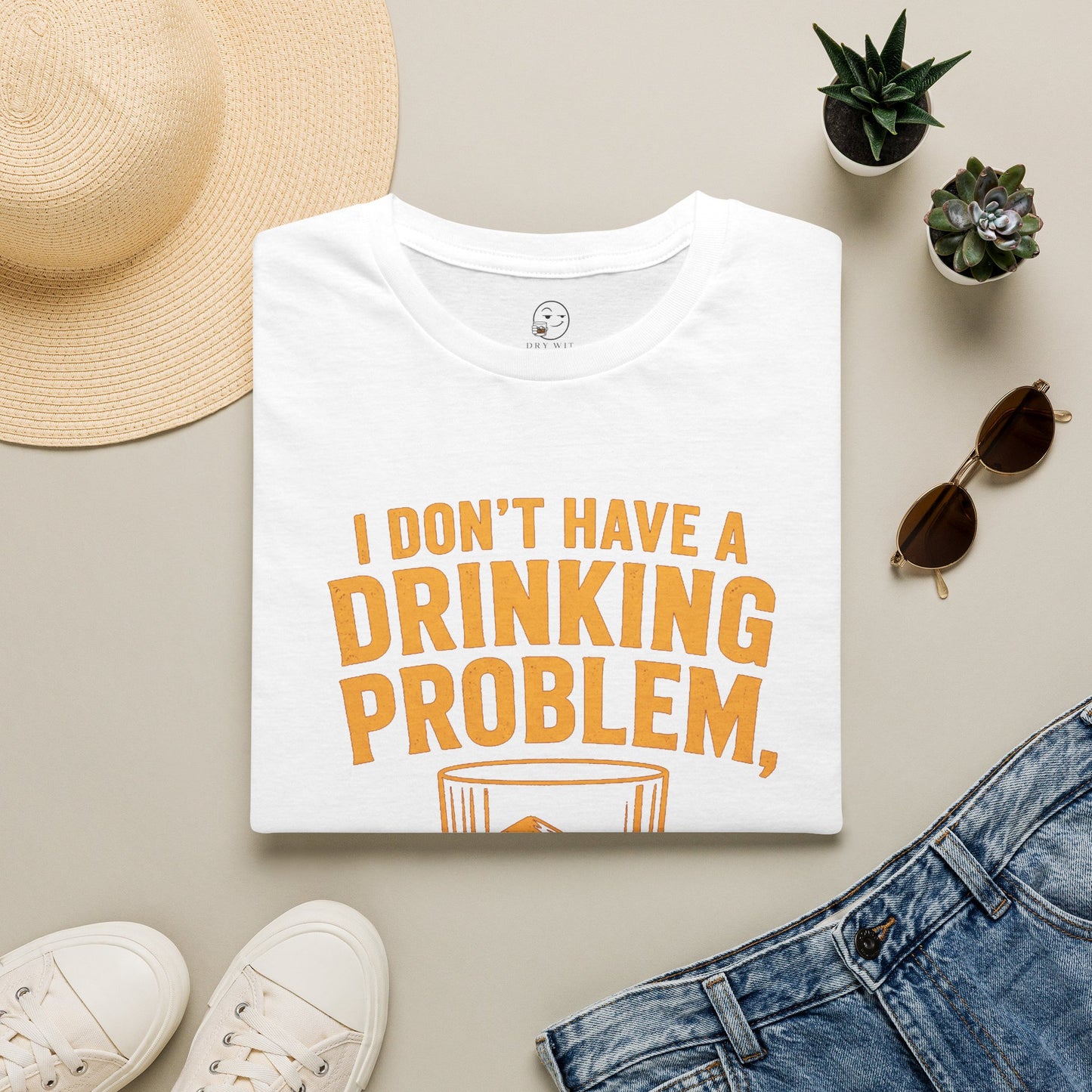 I Don't Have a Drinking Problem Shirt, White, folded flat lay styled with a straw hat, sunglasses, sneakers and denim