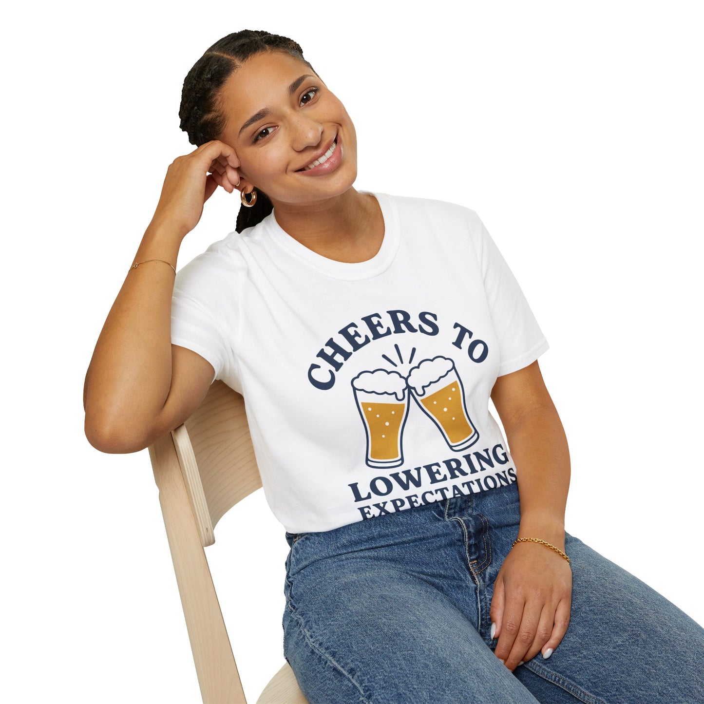 Cheers to Lowering Expectations Shirt, White, worn by a model seated on a wooden chair