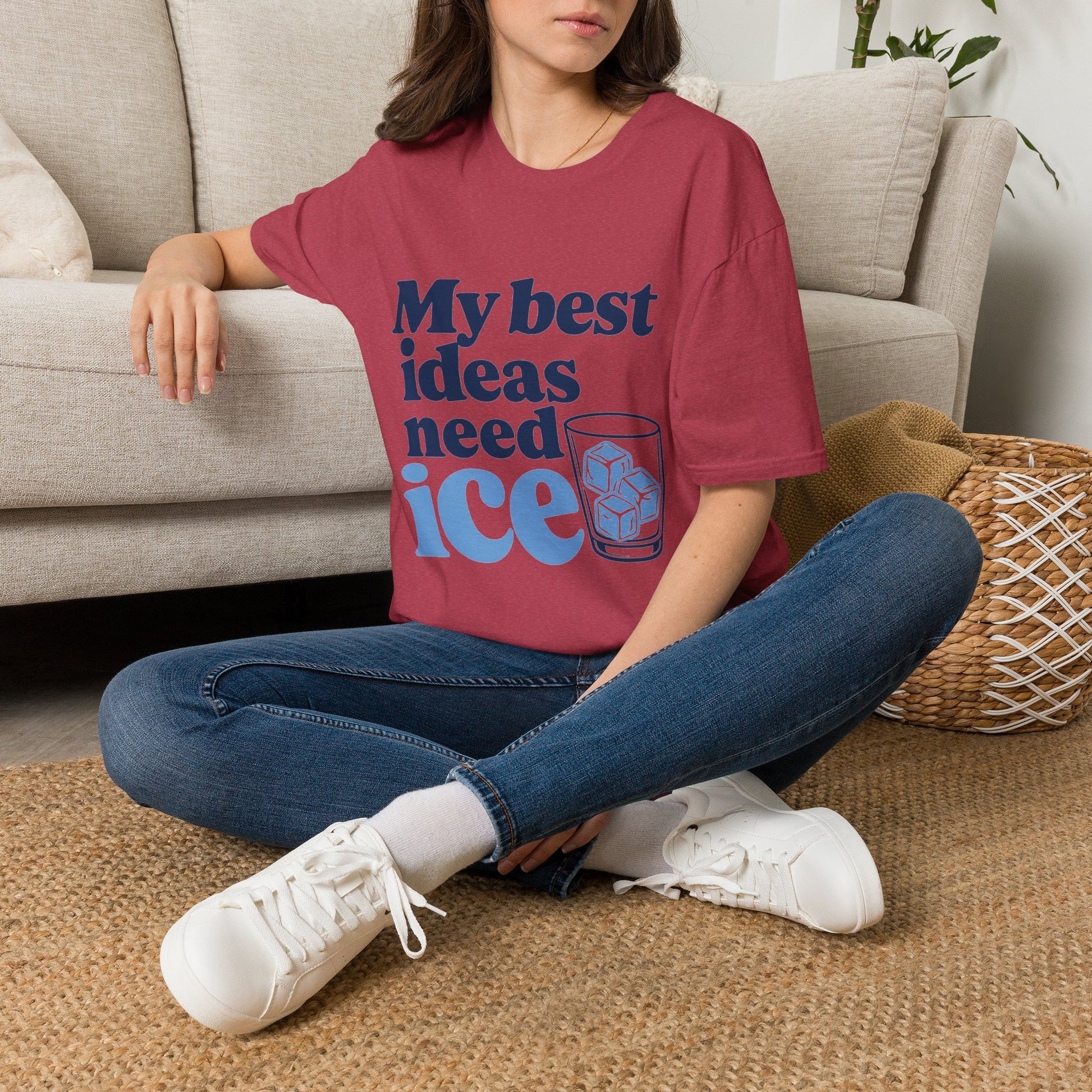 My Best Ideas Need Ice Shirt, Heather Cardinal red, worn by a model seated on the floor beside a sofa