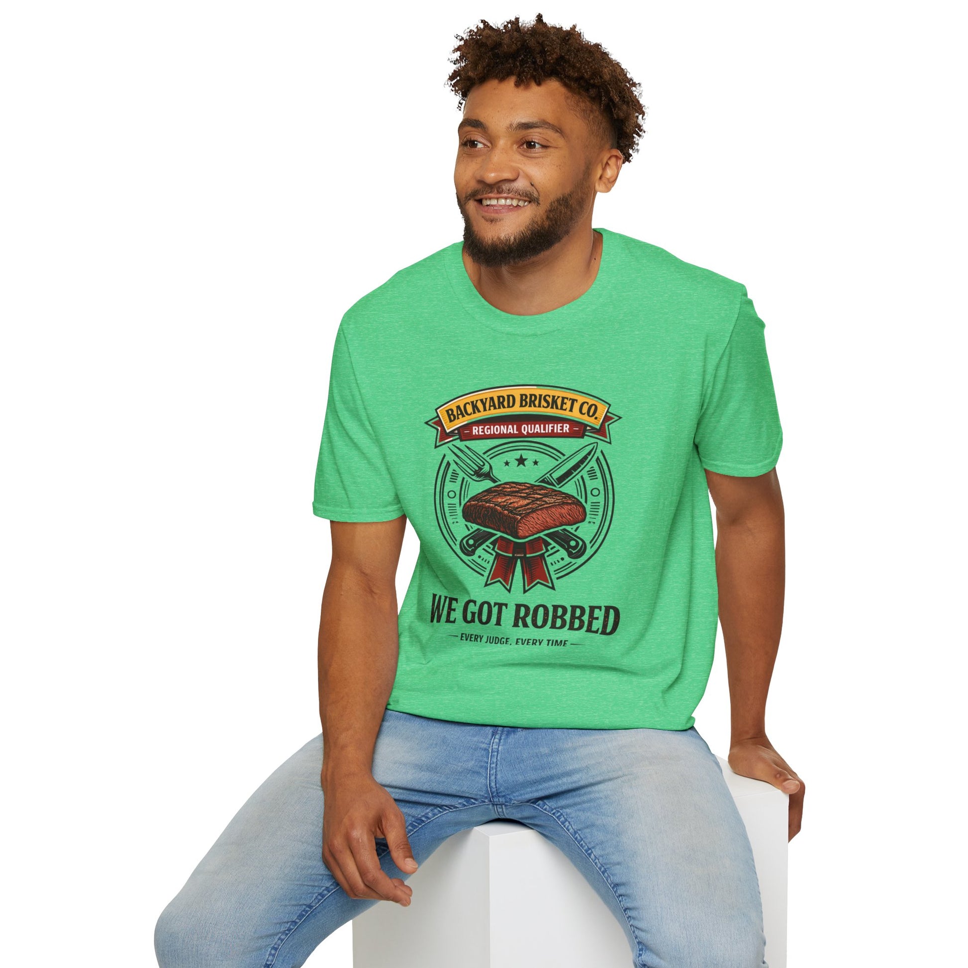 Backyard Brisket Co. Shirt, Heather Irish Green mint, worn by a model seated on a white block