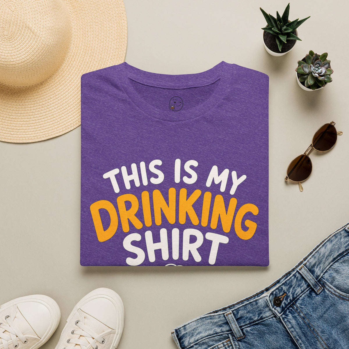 This Is My Drinking Shirt, Heather Purple, folded flat lay styled with a straw hat, sunglasses, sneakers and denim