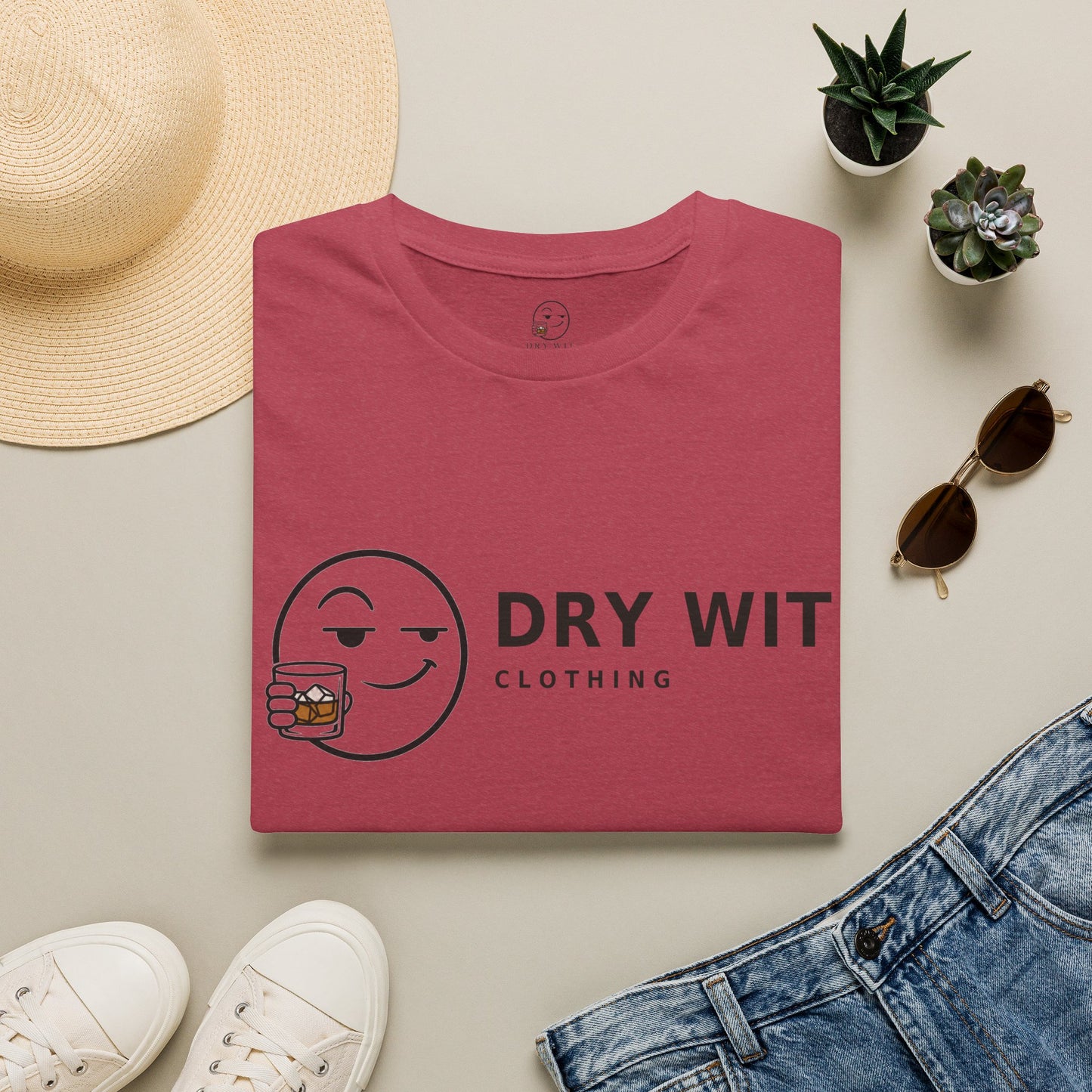 Dry Wit Logo Shirt, Heather Cardinal red, folded flat lay styled with a straw hat, sunglasses, sneakers and denim
