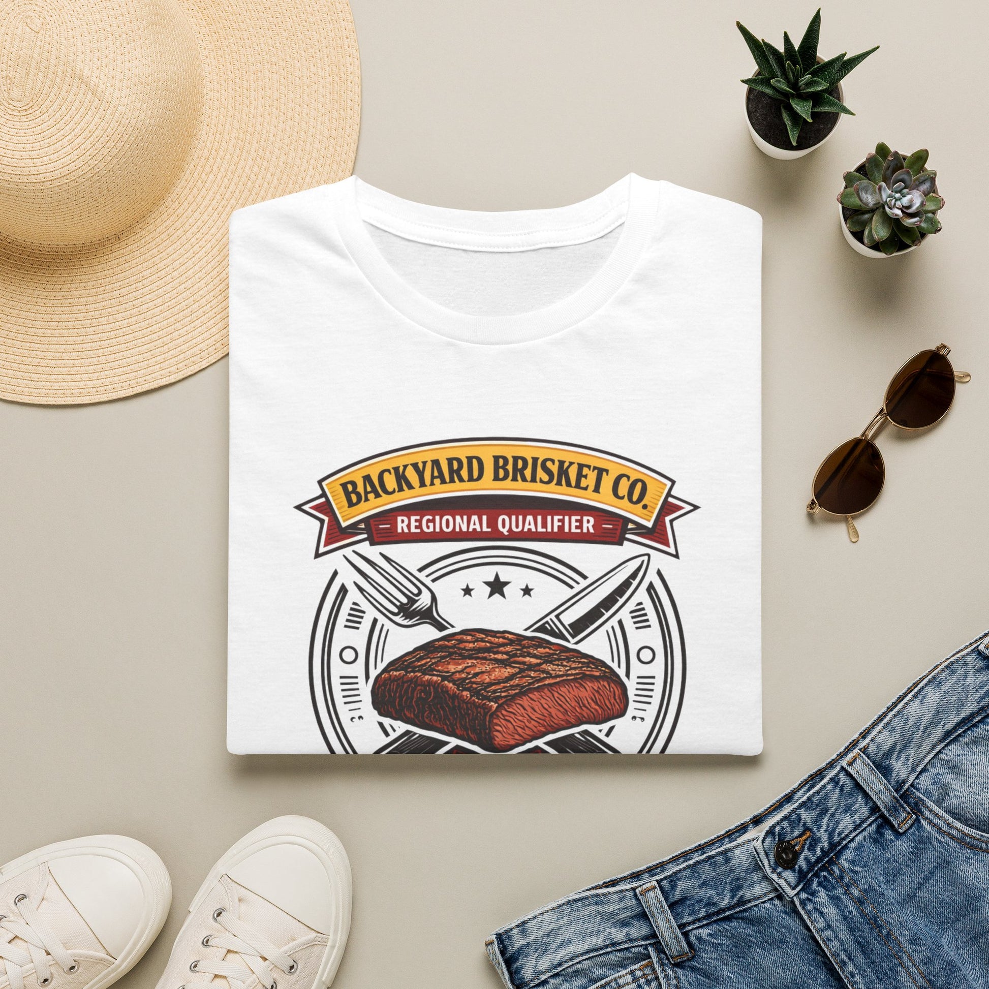 Backyard Brisket Co. Shirt, White, folded flat lay styled with a straw hat, sunglasses, sneakers and denim