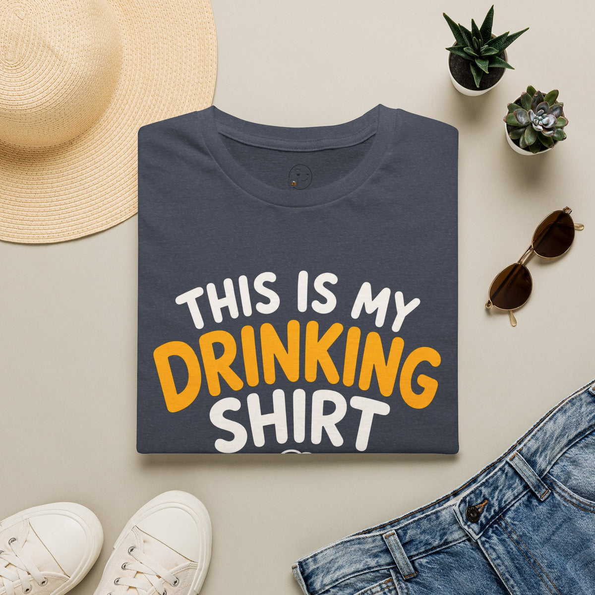 This Is My Drinking Shirt, Heather Navy, folded flat lay styled with a straw hat, sunglasses, sneakers and denim