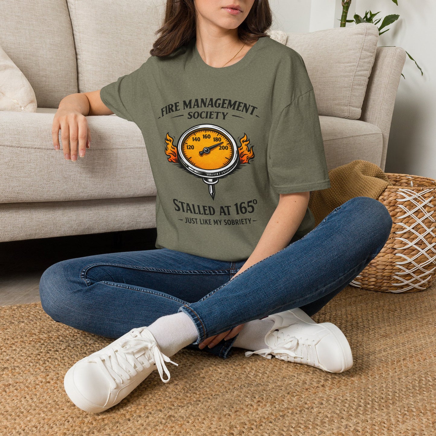 Fire Management Society Shirt, Heather Military Green olive, worn by a model seated on the floor beside a sofa