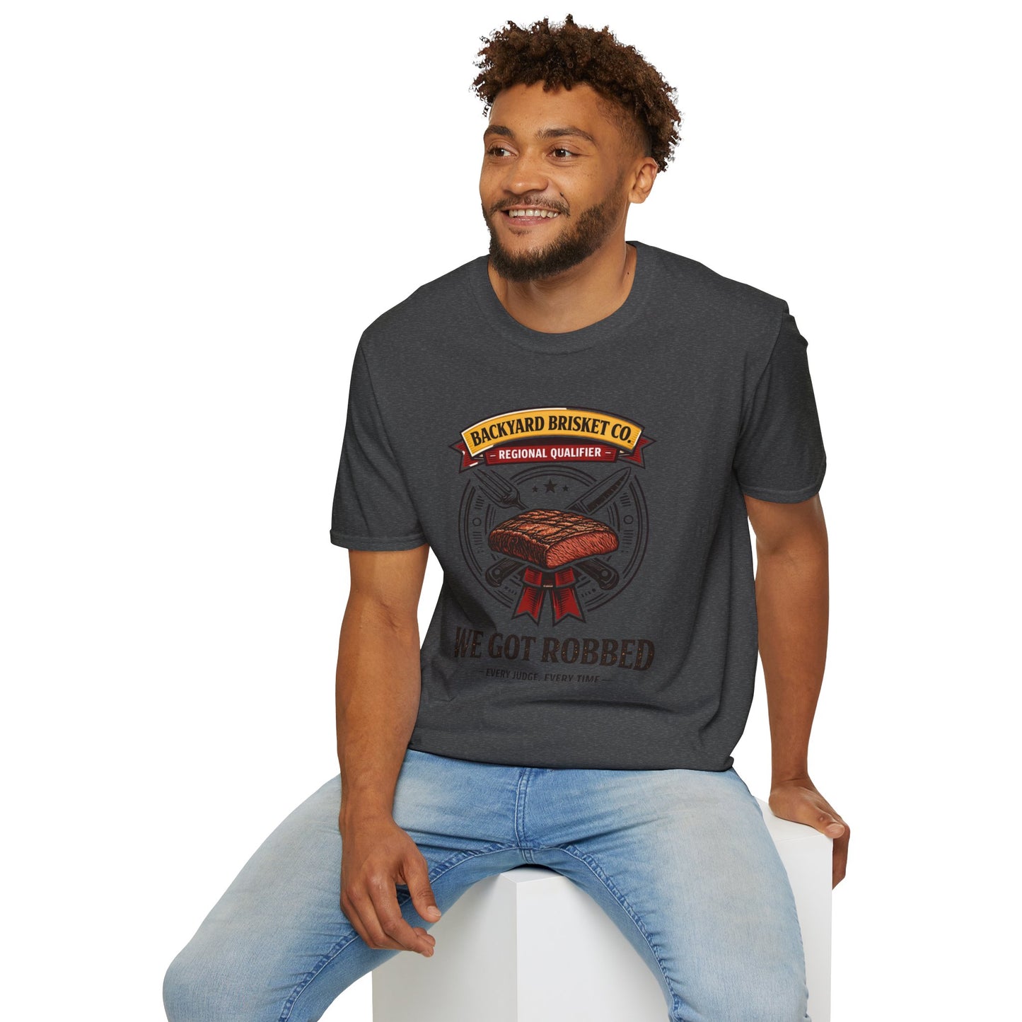 Backyard Brisket Co. Shirt, Dark Heather charcoal, worn by a model seated on a white block