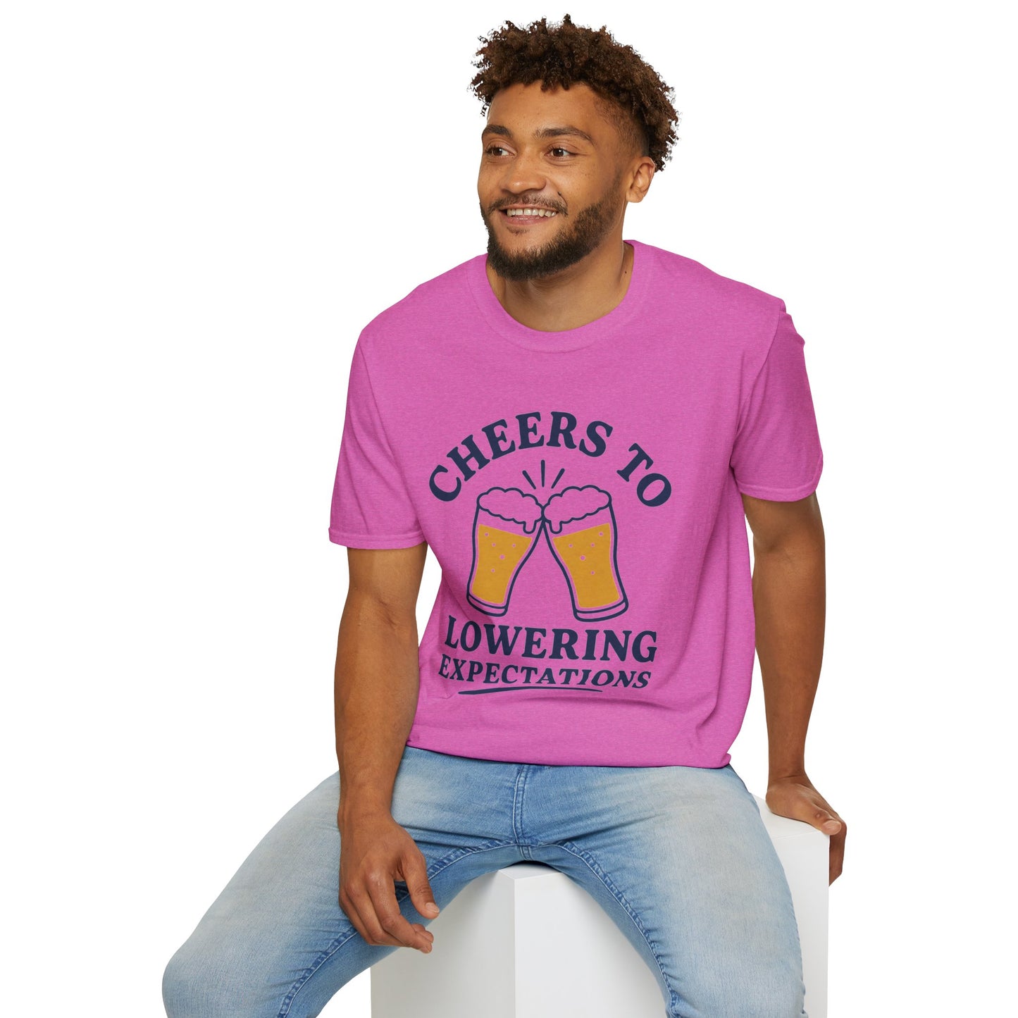 Cheers to Lowering Expectations Shirt, Heather Berry pink, worn by a model seated on a white block