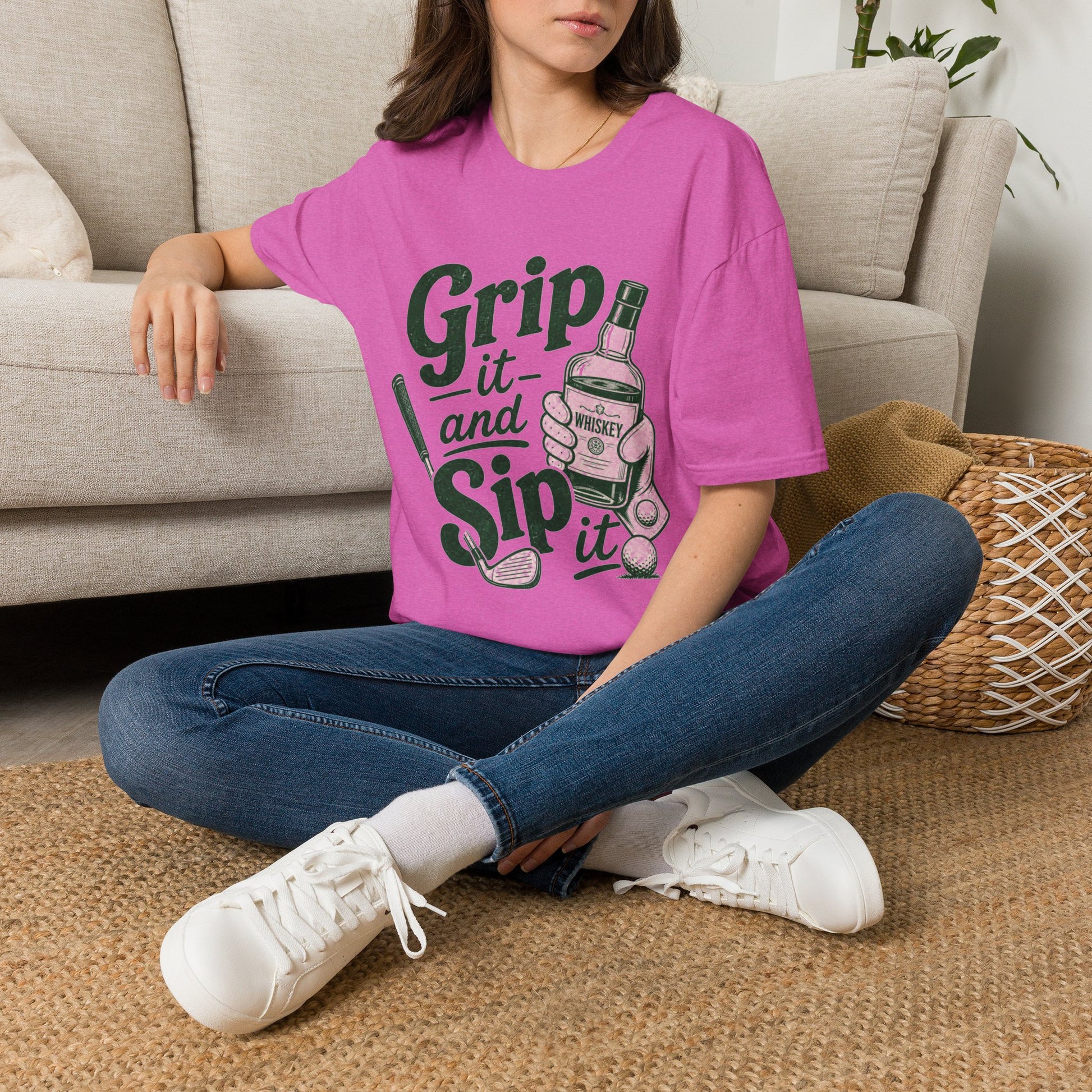 Grip It and Sip It funny golf whiskey shirt, Heather Berry pink, worn by a model seated on a living room floor
