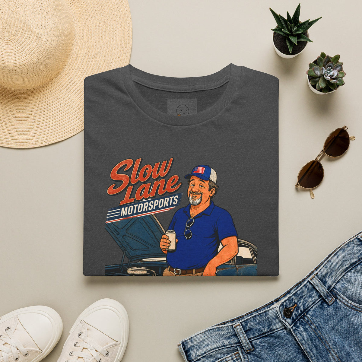 Slow Lane Motorsports Shirt, Dark Heather charcoal, folded flat lay styled with a straw hat, sunglasses, sneakers and denim