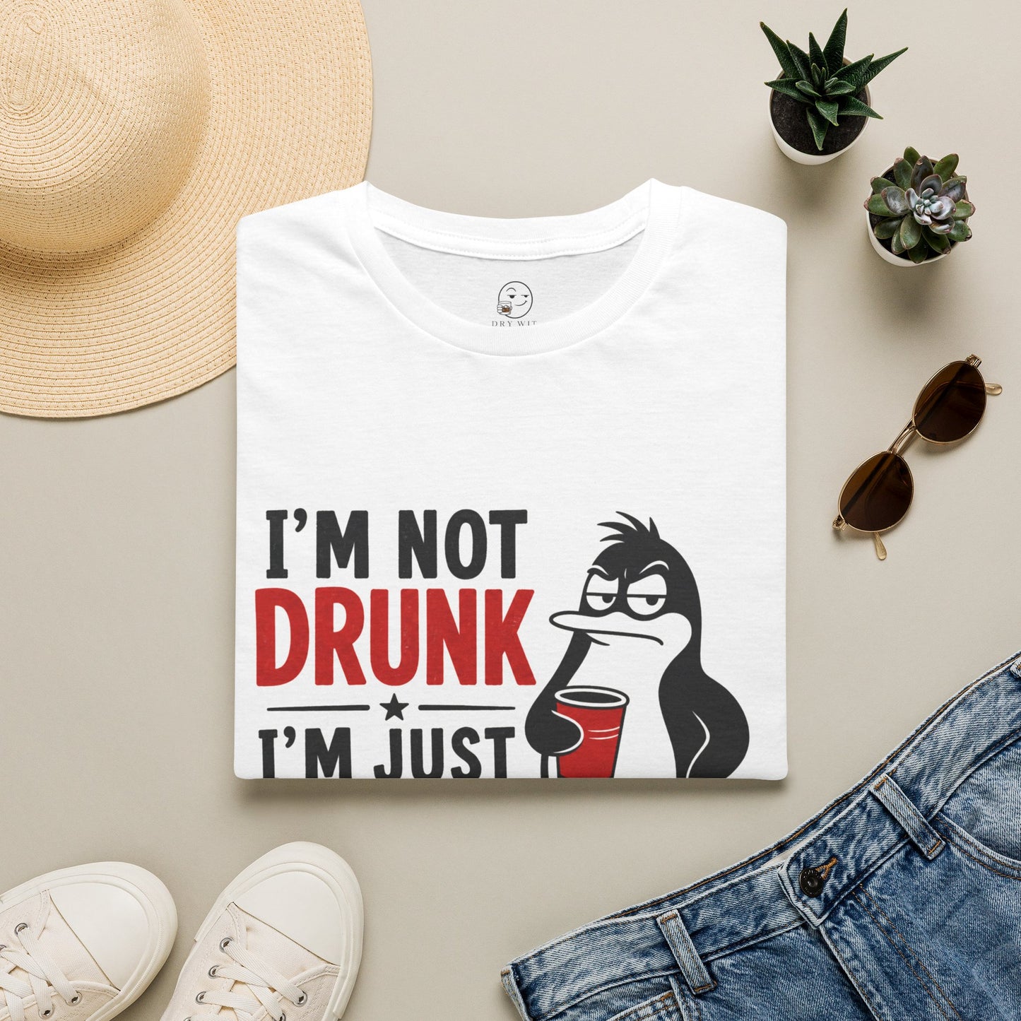 I'm Not Drunk, I'm Just Fluent in Sarcasm Shirt, White, folded flat lay styled with a straw hat, sunglasses, sneakers and denim