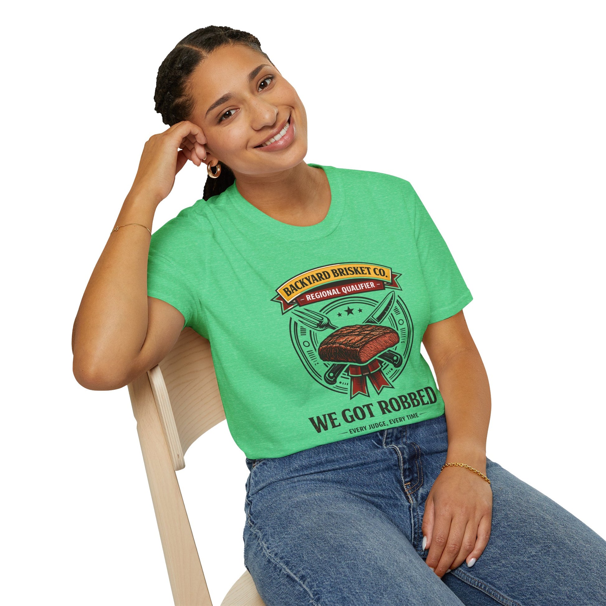 Backyard Brisket Co. Shirt, Heather Irish Green mint, worn by a model seated on a wooden chair