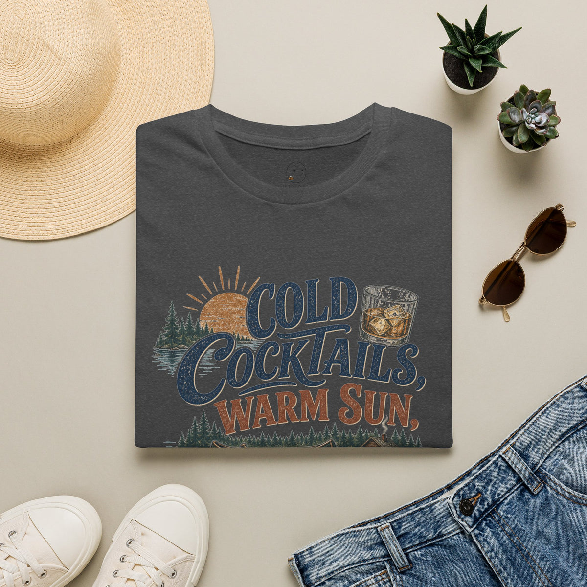 Cold Cocktails, Warm Sun Shirt, Dark Heather charcoal, folded flat lay styled with a straw hat, sunglasses, sneakers and denim