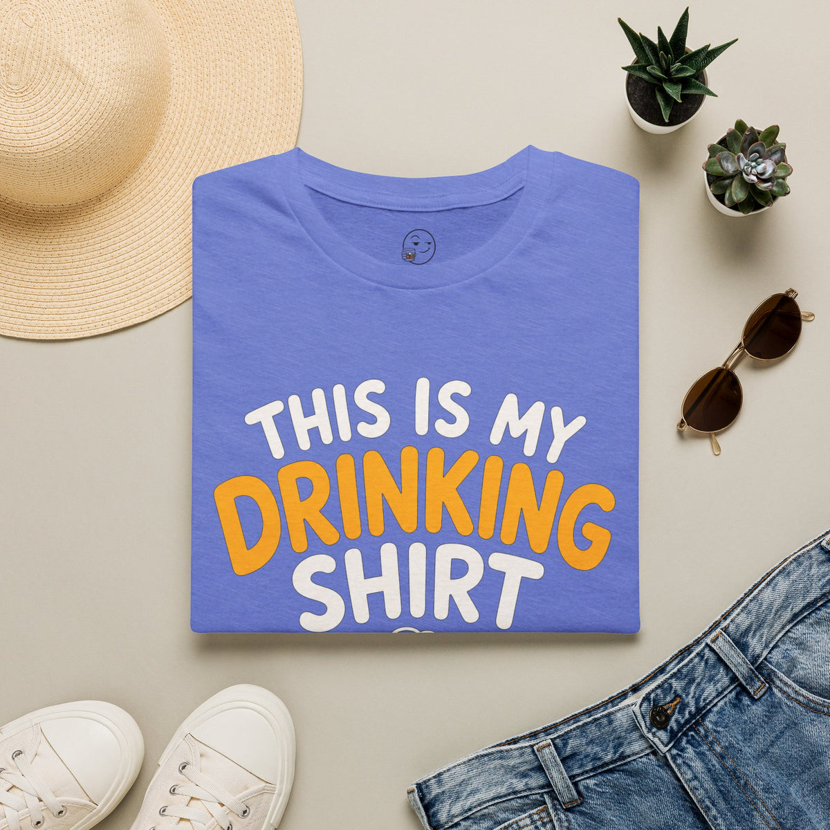 This Is My Drinking Shirt, Heather Royal blue, folded flat lay styled with a straw hat, sunglasses, sneakers and denim