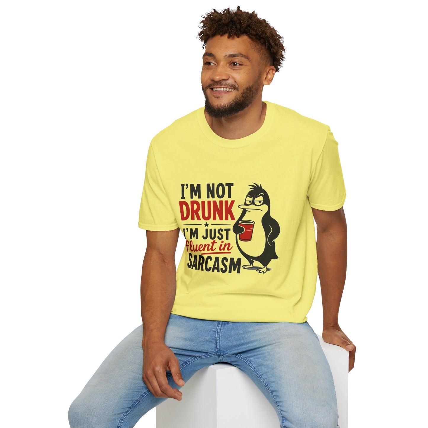 I'm Not Drunk, I'm Just Fluent in Sarcasm Shirt, Cornsilk pale yellow, worn by a model seated on a white block