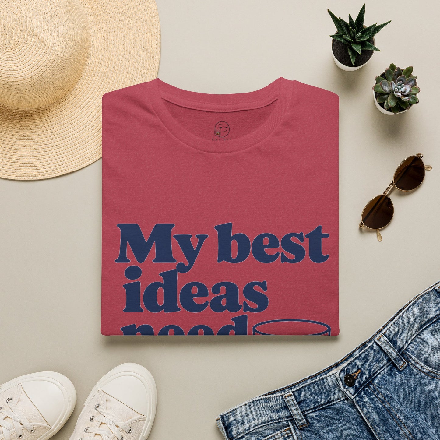 My Best Ideas Need Ice Shirt, Heather Cardinal red, folded flat lay styled with a straw hat, sunglasses, sneakers and denim