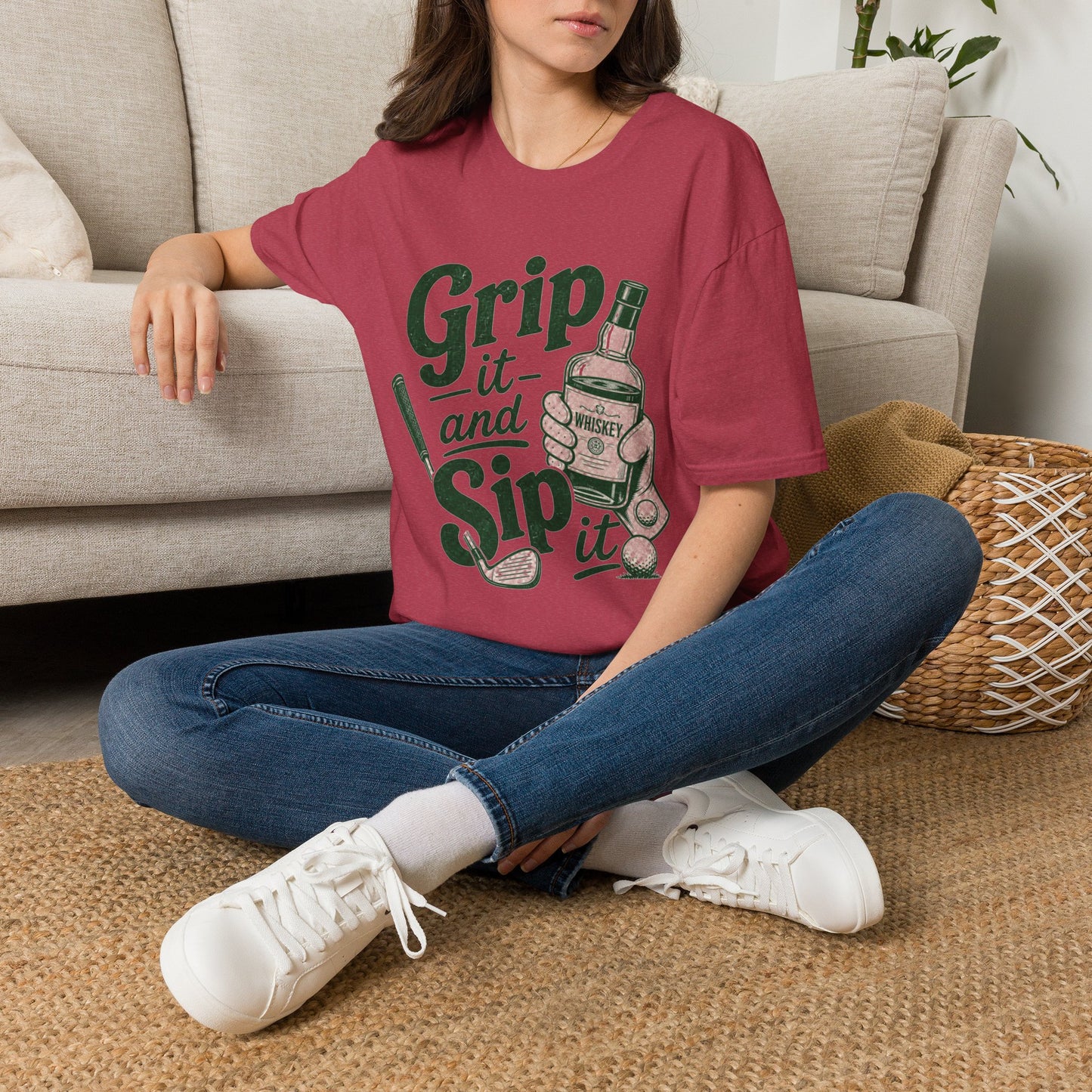 Grip It and Sip It funny golf whiskey shirt, Heather Cardinal red, worn by a model seated on a living room floor