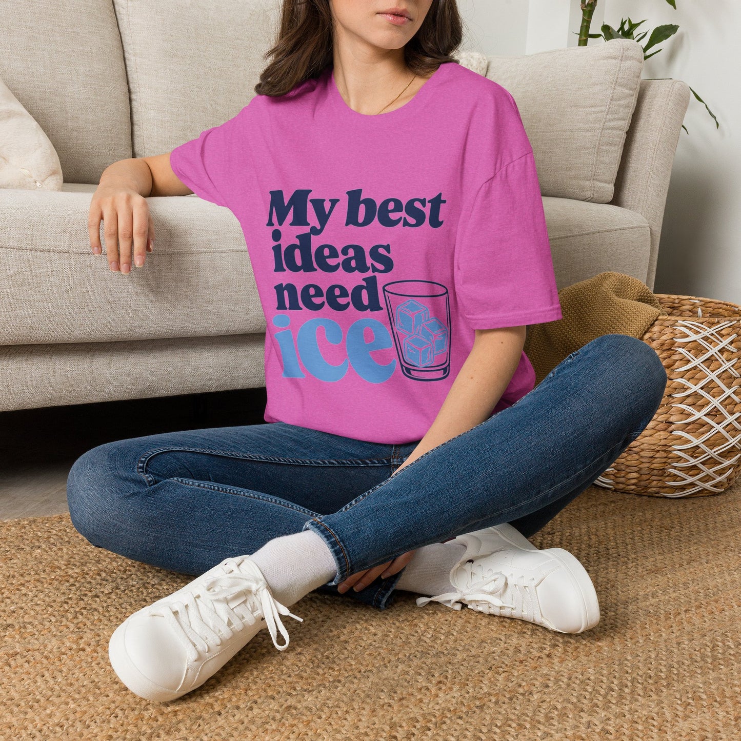 My Best Ideas Need Ice Shirt, Heather Berry pink, worn by a model seated on the floor beside a sofa