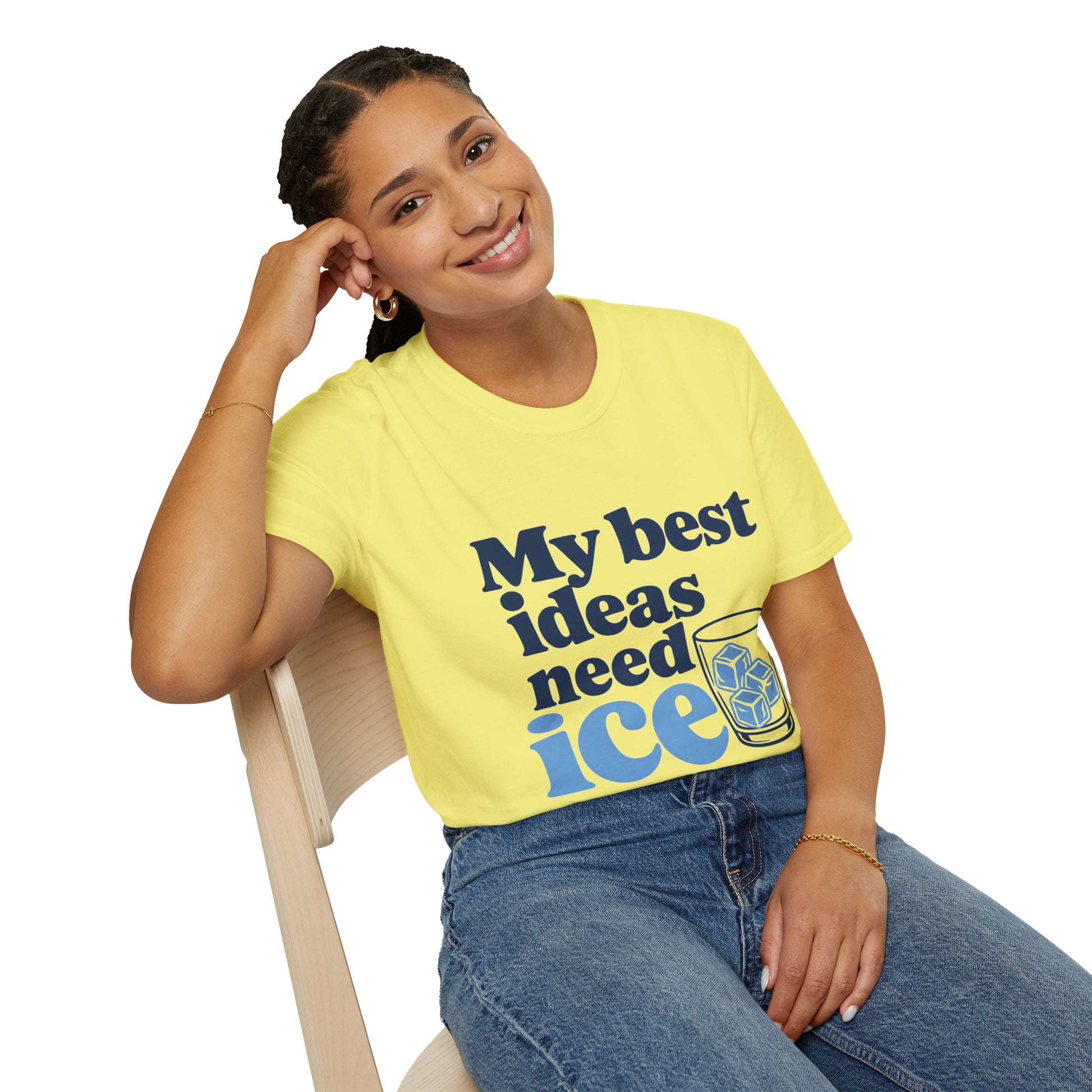 My Best Ideas Need Ice Shirt, Cornsilk pale yellow, worn by a model seated on a wooden chair