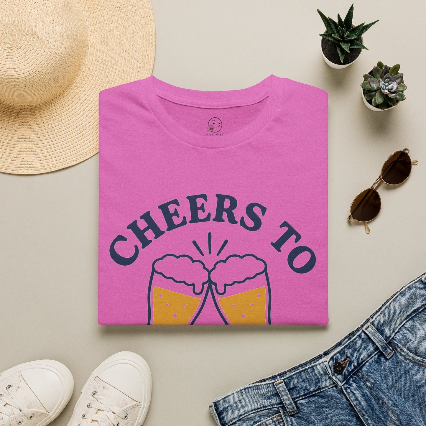 Cheers to Lowering Expectations Shirt, Heather Berry pink, folded flat lay styled with a straw hat, sunglasses, sneakers and denim
