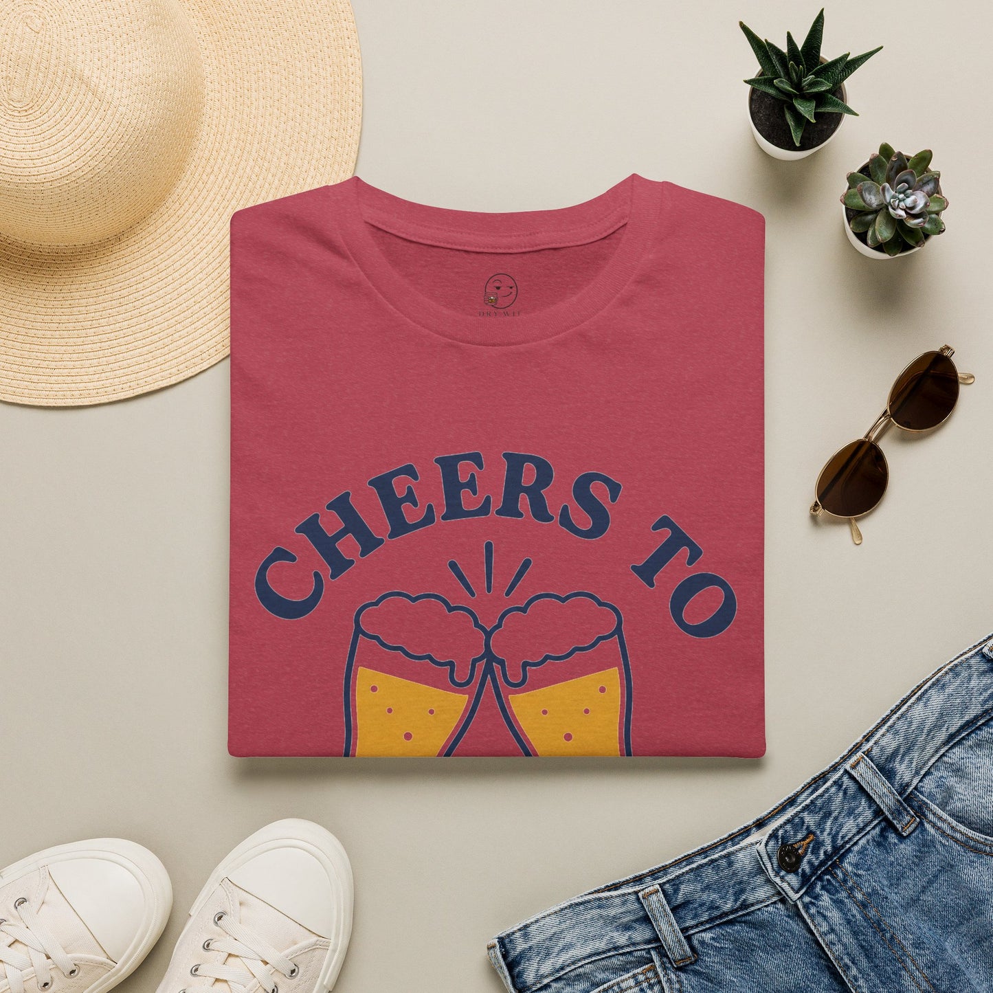Cheers to Lowering Expectations Shirt, Heather Cardinal red, folded flat lay styled with a straw hat, sunglasses, sneakers and denim