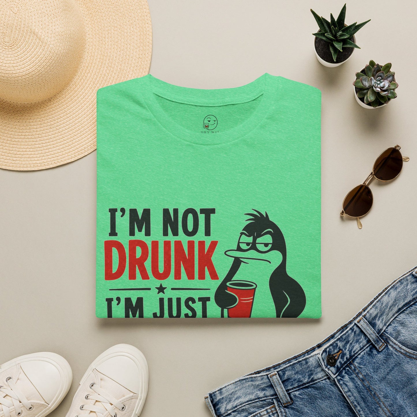 I'm Not Drunk, I'm Just Fluent in Sarcasm Shirt, Heather Irish Green mint, folded flat lay styled with a straw hat, sunglasses, sneakers and denim