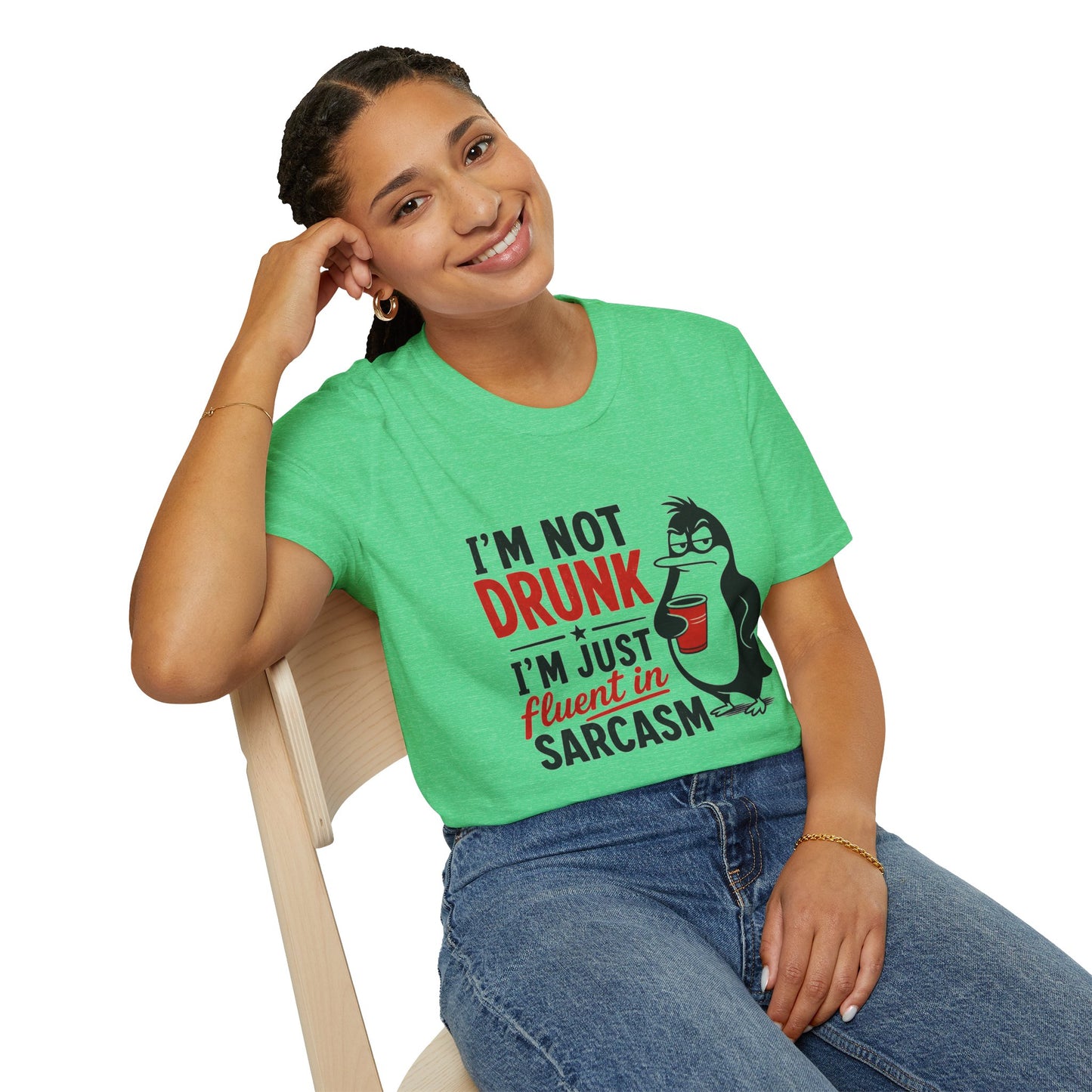 I'm Not Drunk, I'm Just Fluent in Sarcasm Shirt, Heather Irish Green mint, worn by a model seated on a wooden chair