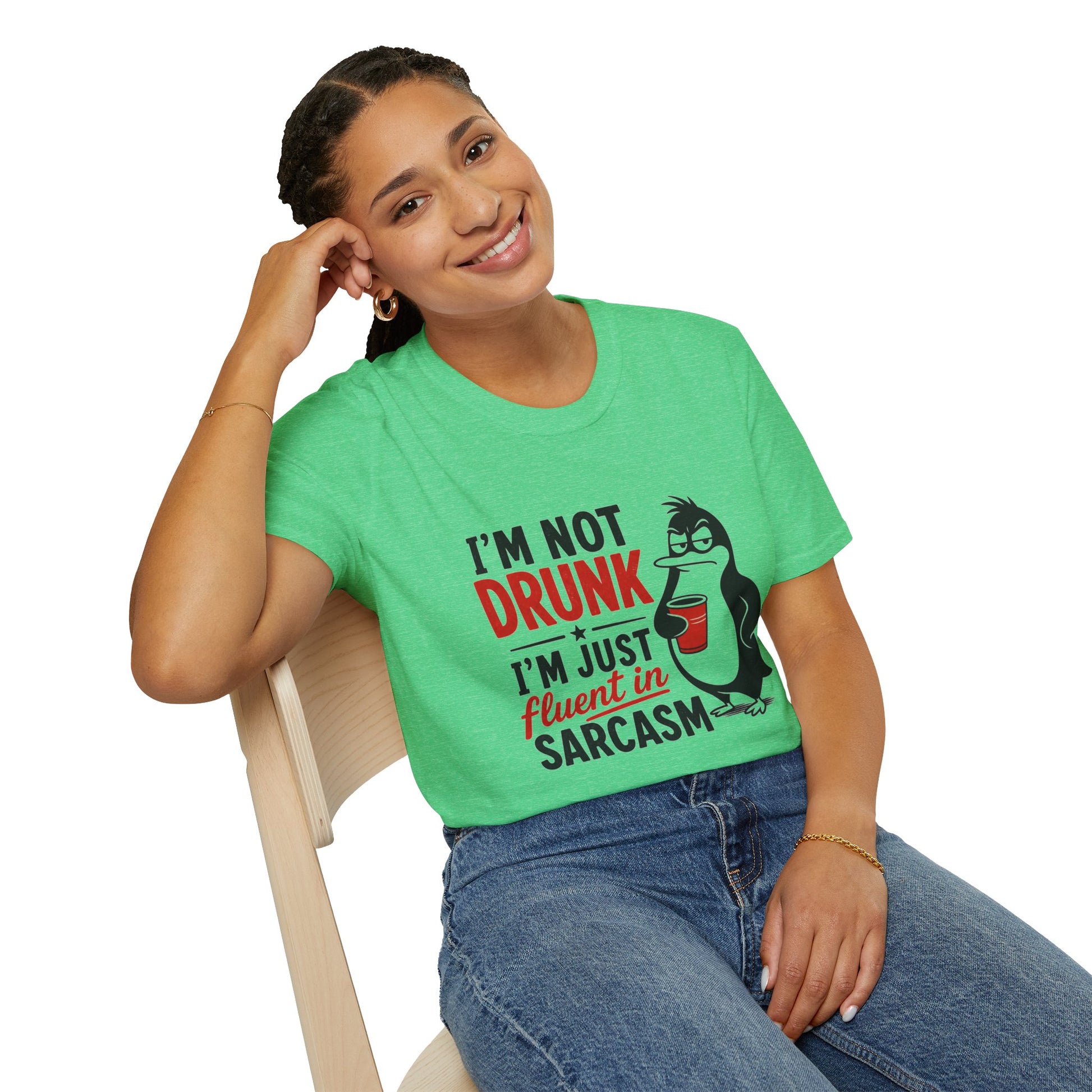 I'm Not Drunk, I'm Just Fluent in Sarcasm Shirt, Heather Irish Green mint, worn by a model seated on a wooden chair