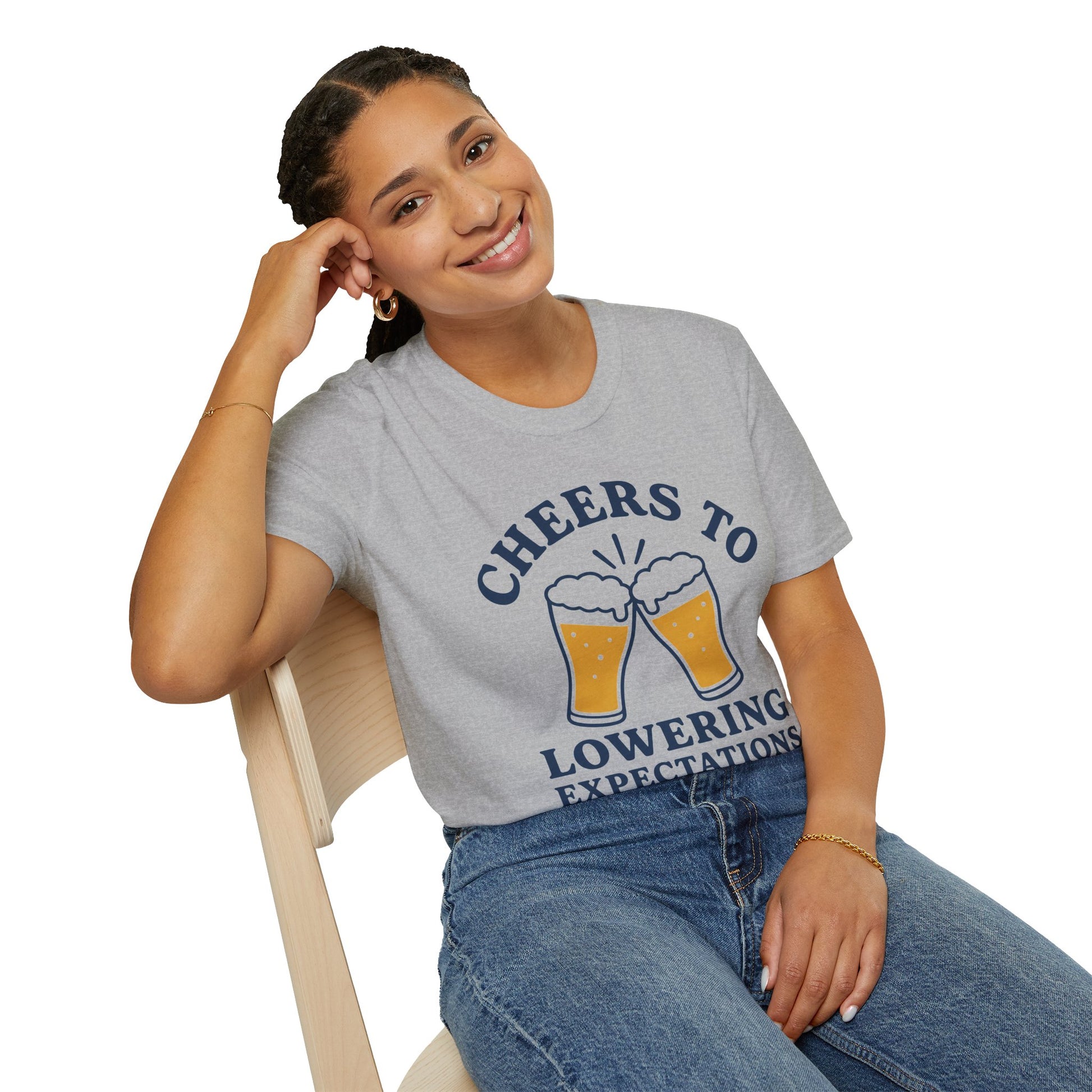 Cheers to Lowering Expectations Shirt, Sport Grey, worn by a model seated on a wooden chair
