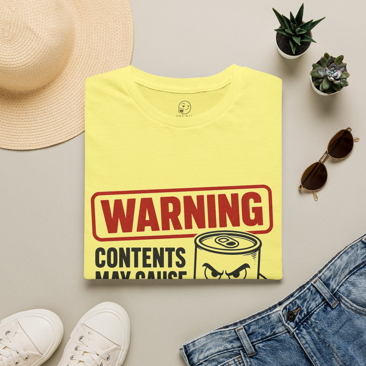 Warning: Contents May Cause Brutal Honesty Shirt, Cornsilk pale yellow, folded flat lay styled with a straw hat, sunglasses, sneakers and denim
