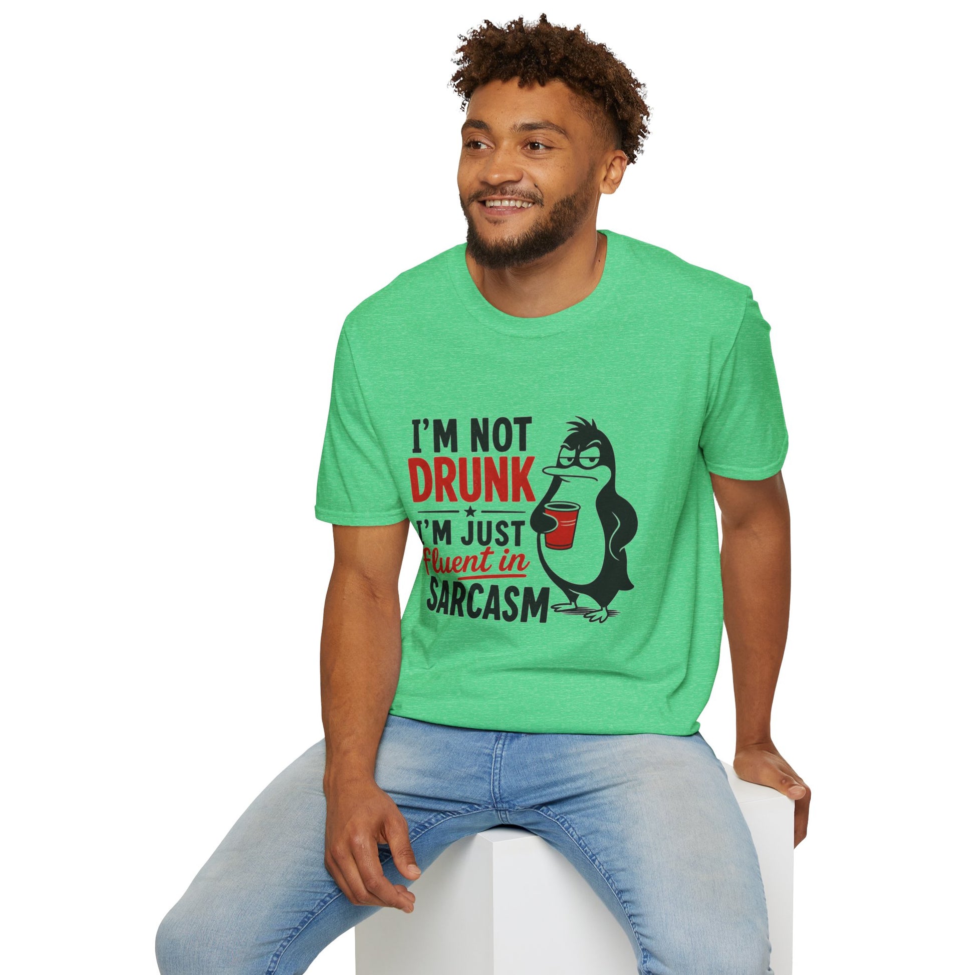 I'm Not Drunk, I'm Just Fluent in Sarcasm Shirt, Heather Irish Green mint, worn by a model seated on a white block