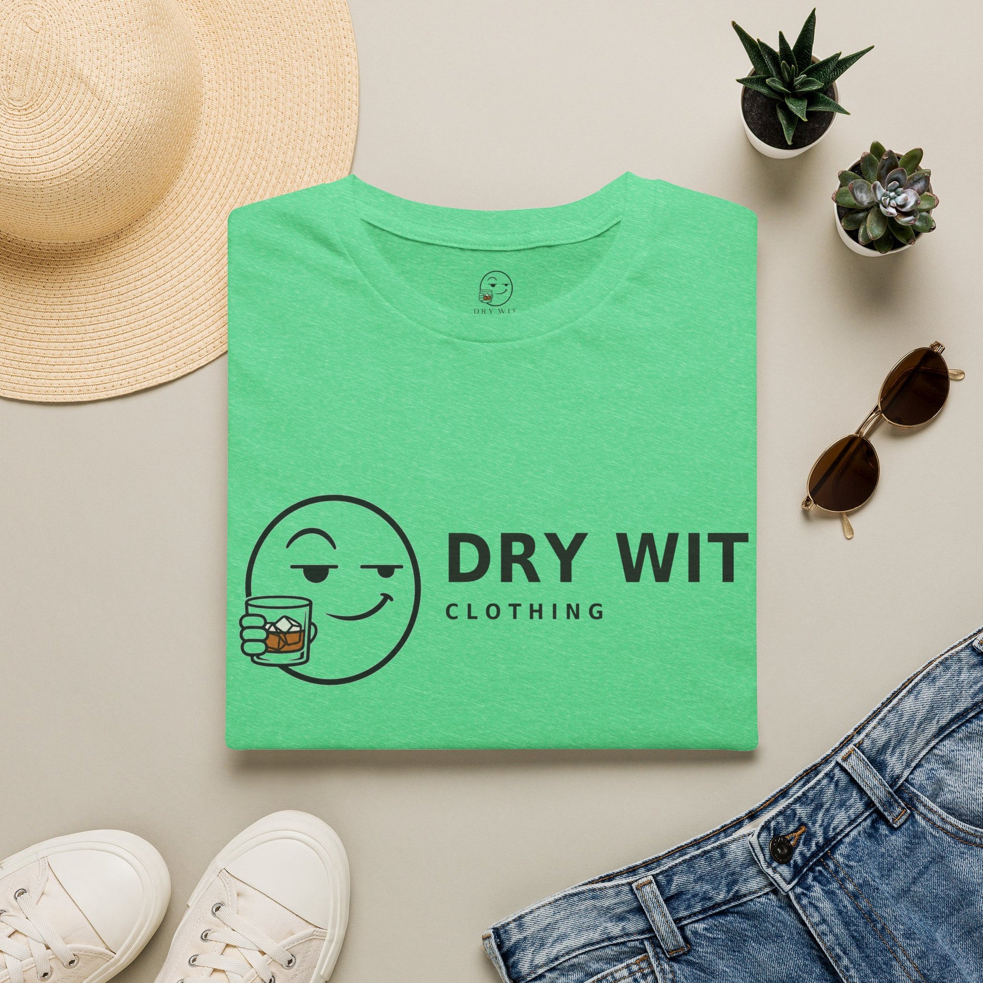Dry Wit Logo Shirt, Heather Irish Green mint, folded flat lay styled with a straw hat, sunglasses, sneakers and denim