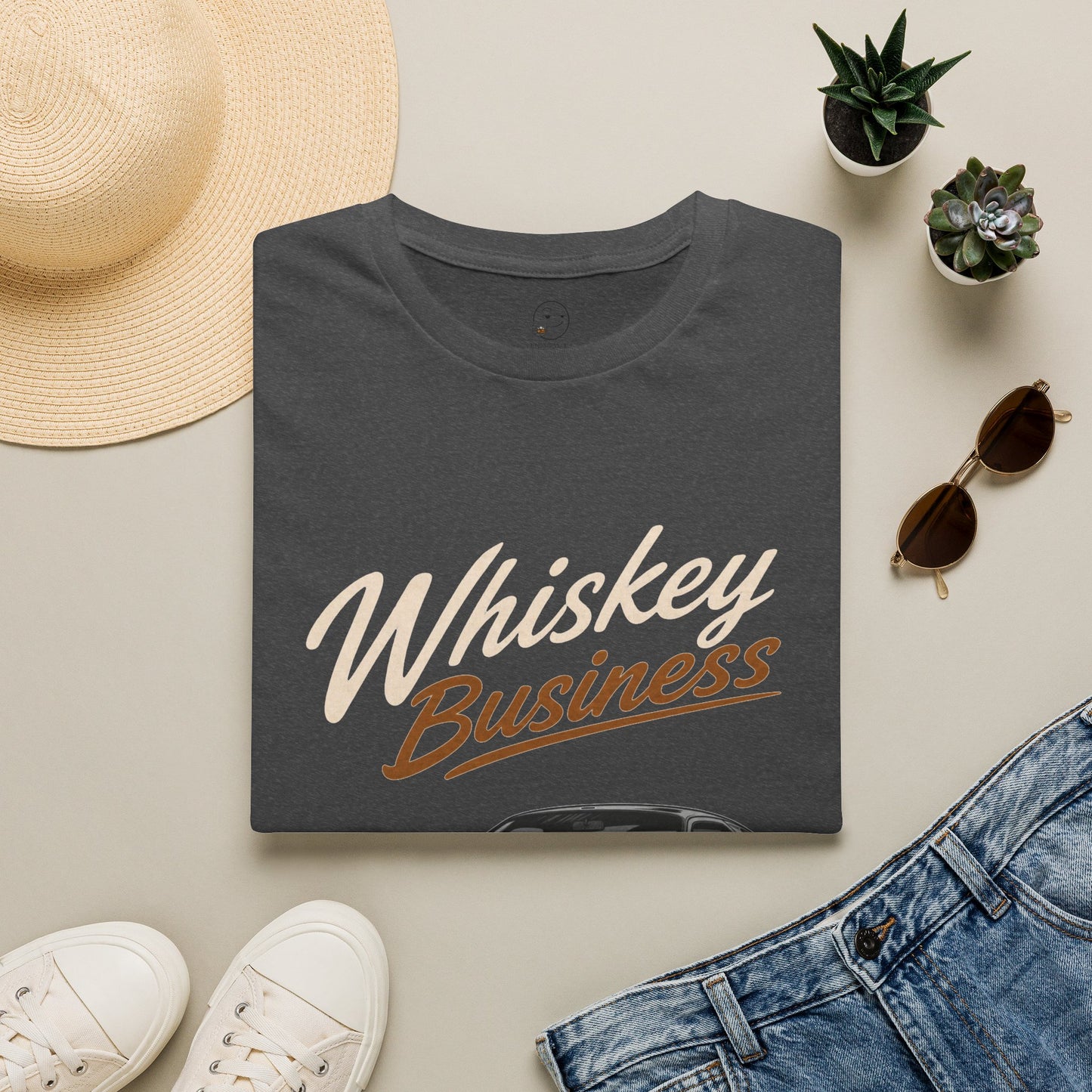 Whiskey Business Shirt, Dark Heather charcoal, folded flat lay styled with a straw hat, sunglasses, sneakers and denim