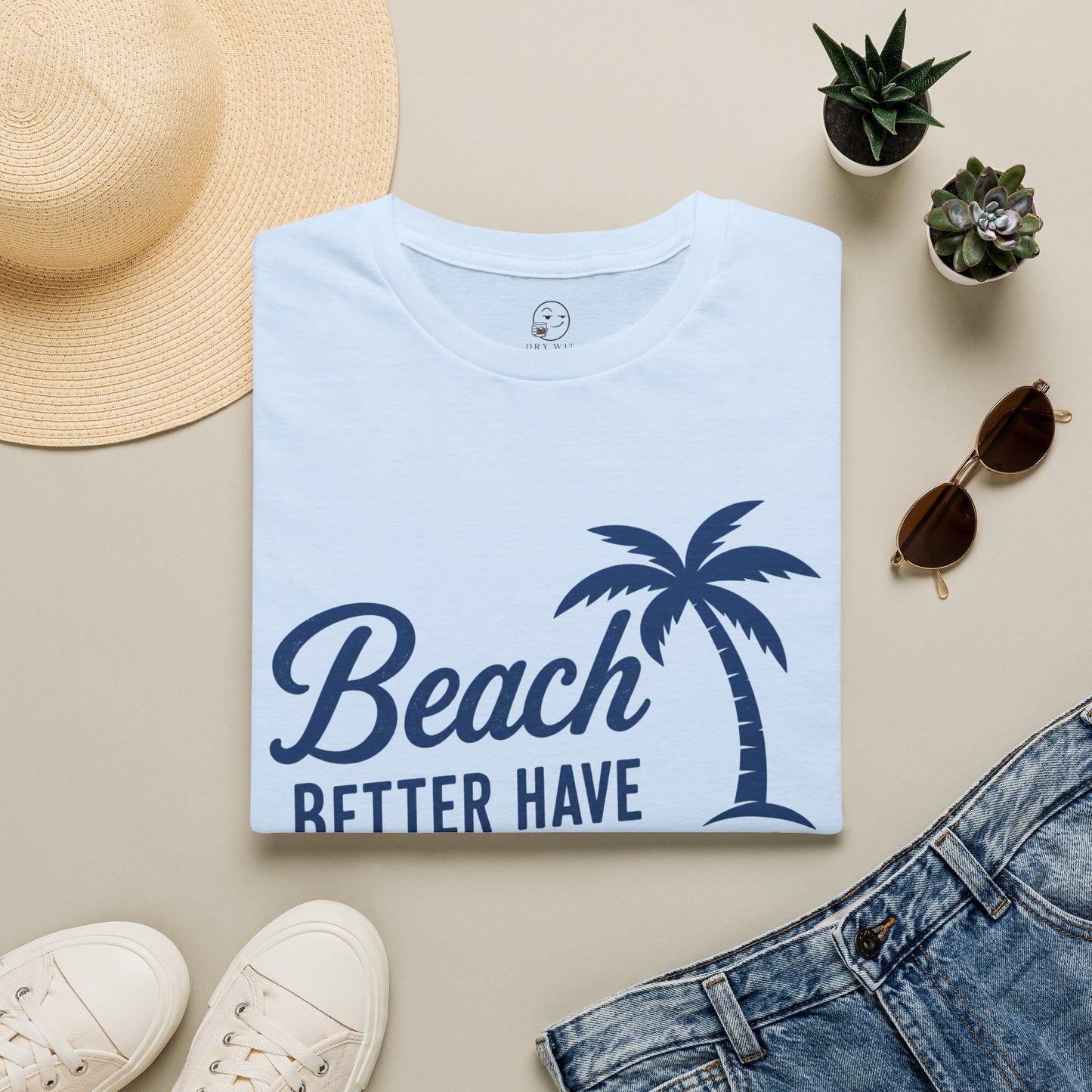 Beach Better Have My Cocktail Shirt, Light Blue, folded flat lay styled with a straw hat, sunglasses, sneakers and denim