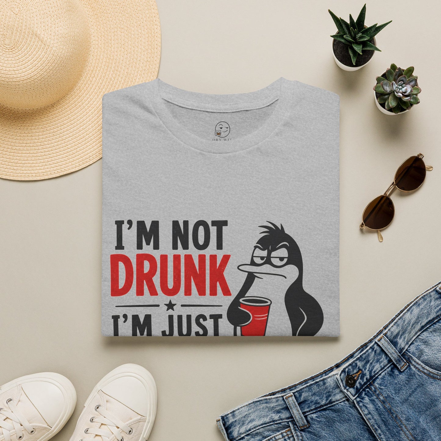 I'm Not Drunk, I'm Just Fluent in Sarcasm Shirt, Sport Grey, folded flat lay styled with a straw hat, sunglasses, sneakers and denim