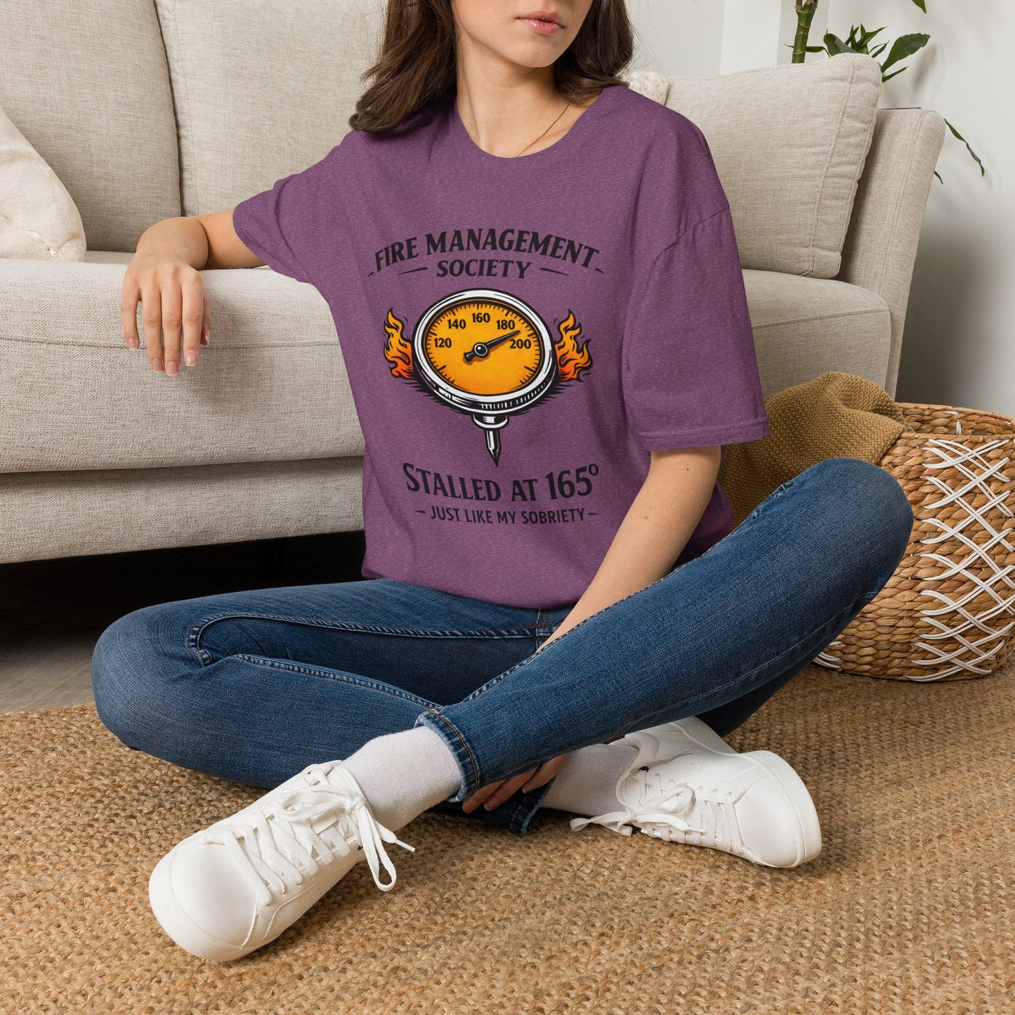 Fire Management Society Shirt, Heather Maroon plum, worn by a model seated on the floor beside a sofa